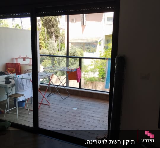 תריסים סגורים מעל דלת זכוכית במרפסת